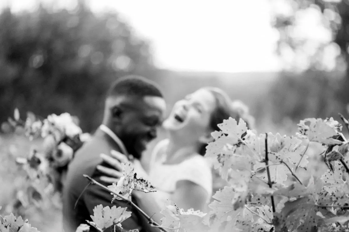 The couple laughing among the foliage, in black and white