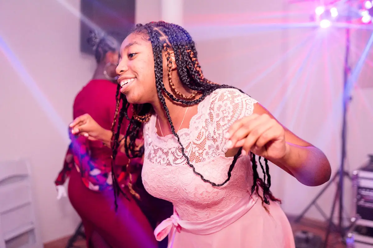 Guest in a pink dress dancing under the lights at the party in Camblanes-et-Meynac
