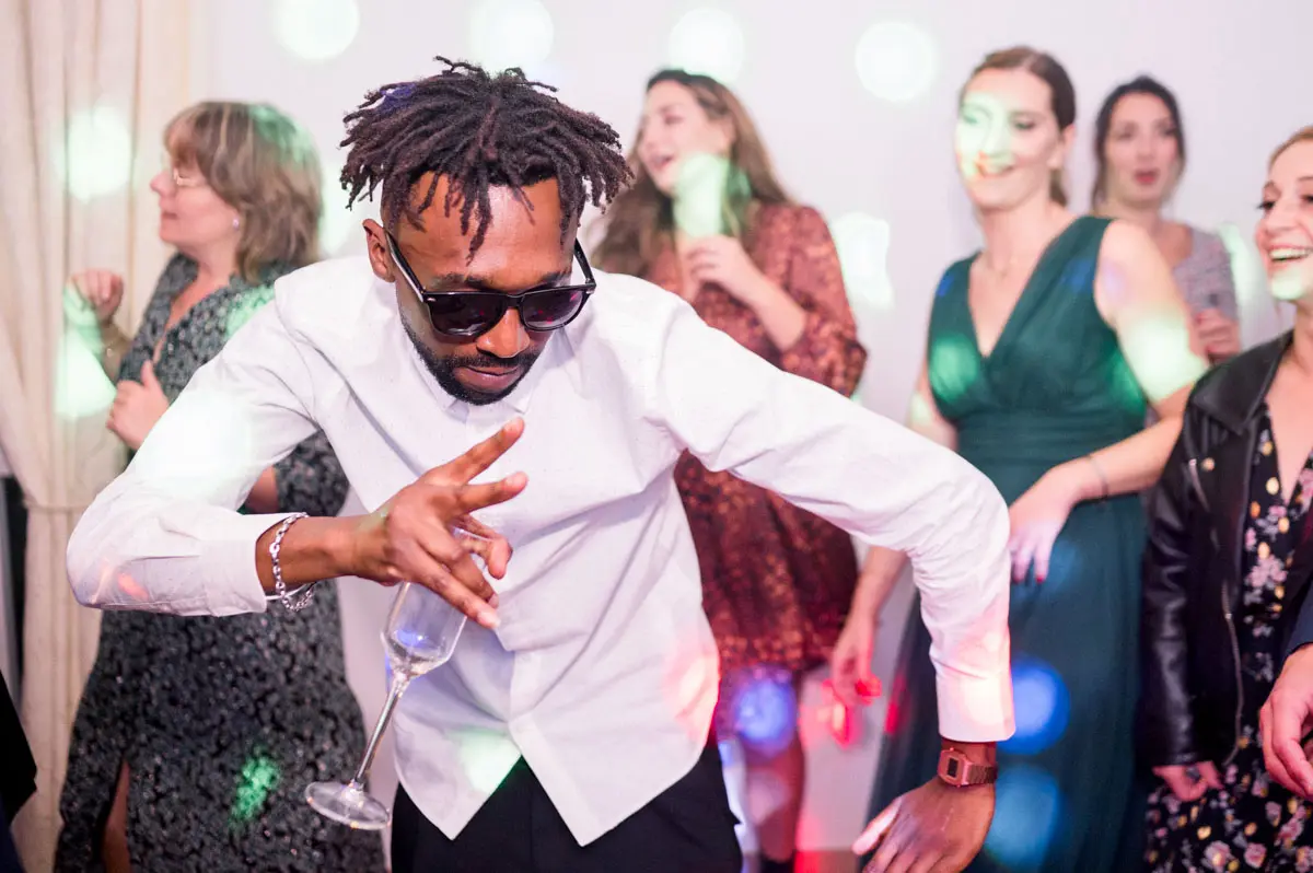 Guest in sunglasses dancing energetically during the evening party