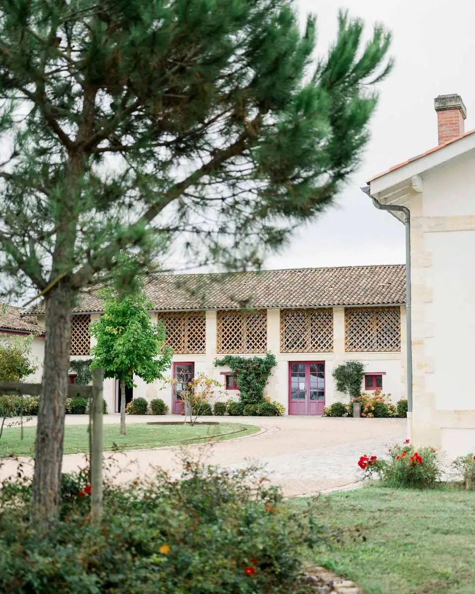 Winery buildings of Château Duplessis with plum shutters and flower garden