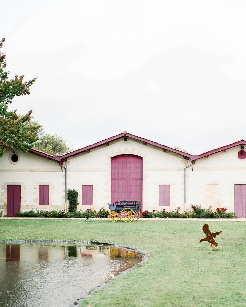 Château Duplessis building with burgundy doors beside a pond