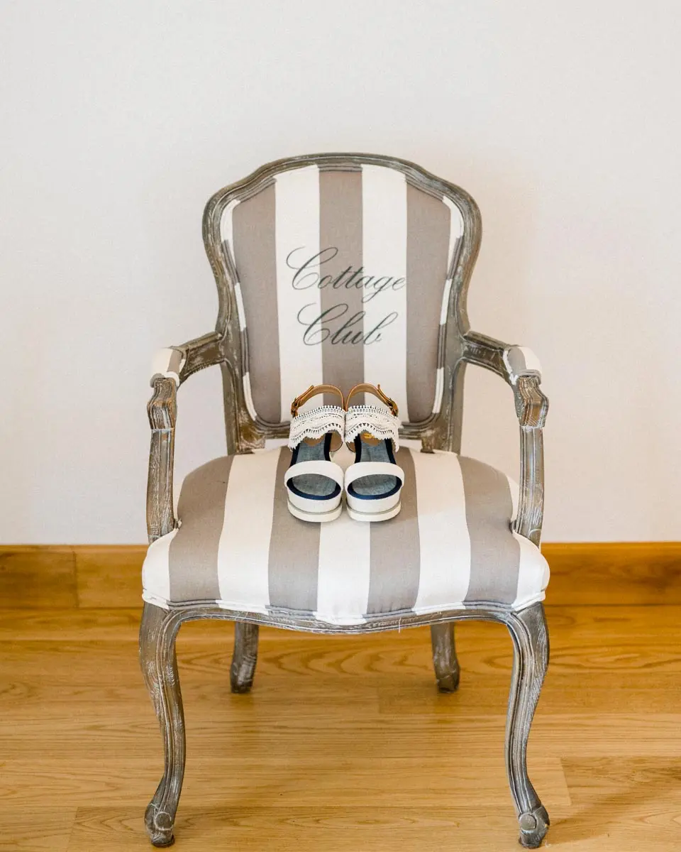 Bride's shoes resting on a grey and white striped armchair