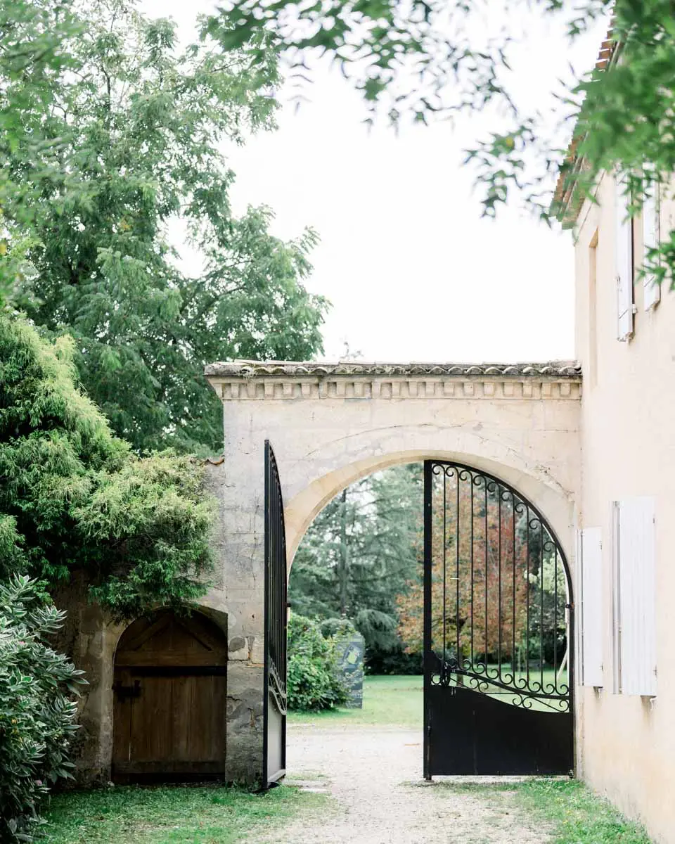 Arched gateway opening onto the tree-lined drive of Château Duplessis