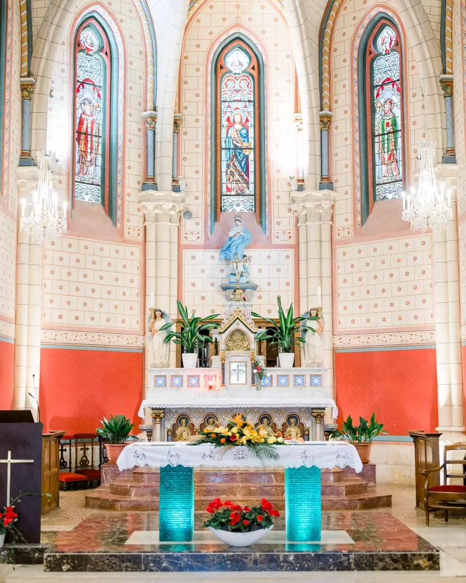 Colourful church choir with stained glass and a flower-decked altar