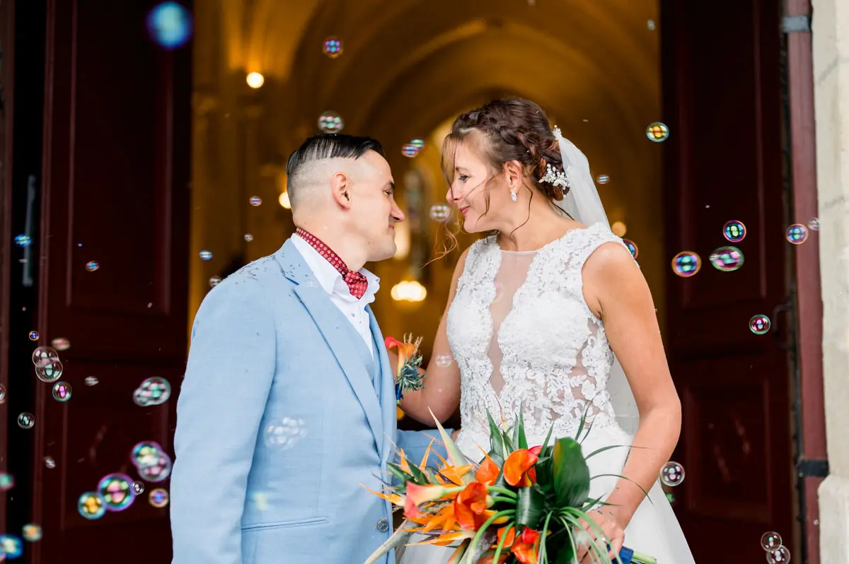 Newlyweds under soap bubbles as they leave the church
