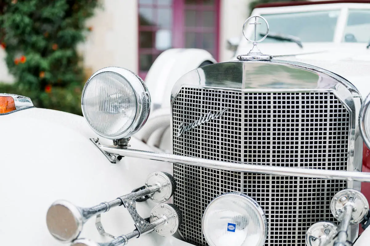 Chrome grille and headlights of a white vintage wedding car
