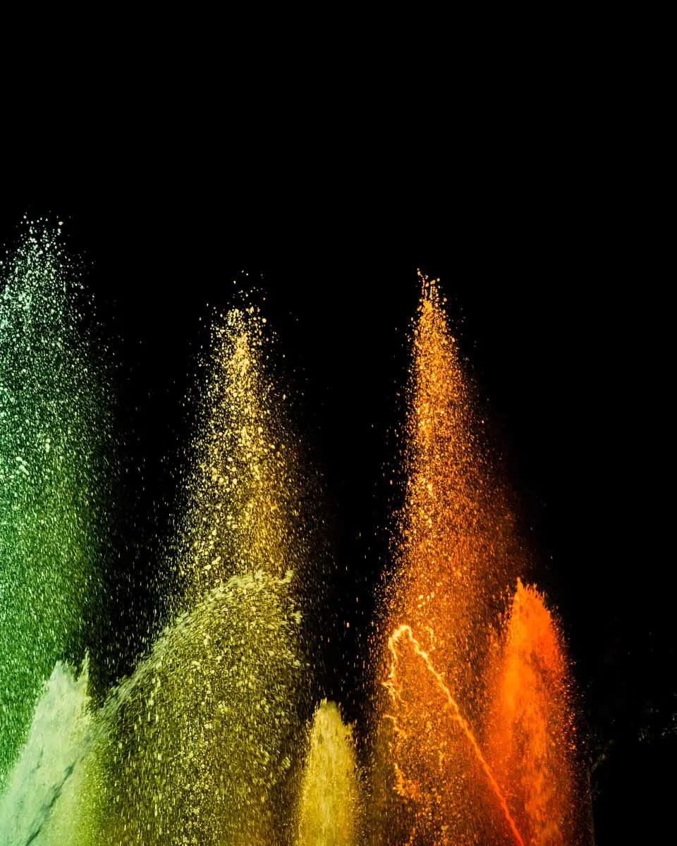 Green and orange water jets lit up in the night at Château Duplessis