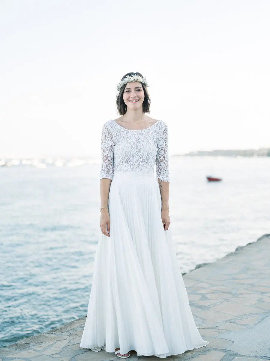 The bride facing the camera on the sea wall with Arcachon Bay behind her