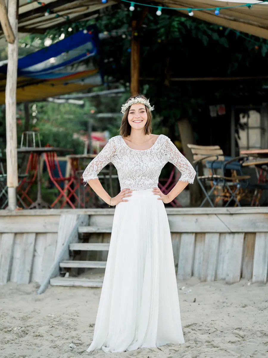 The bride with hands on hips in front of a beach shack terrace