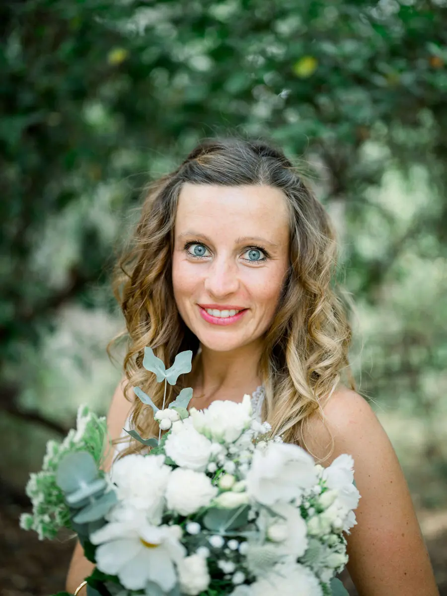 Close-up of a smiling mother holding white flowers