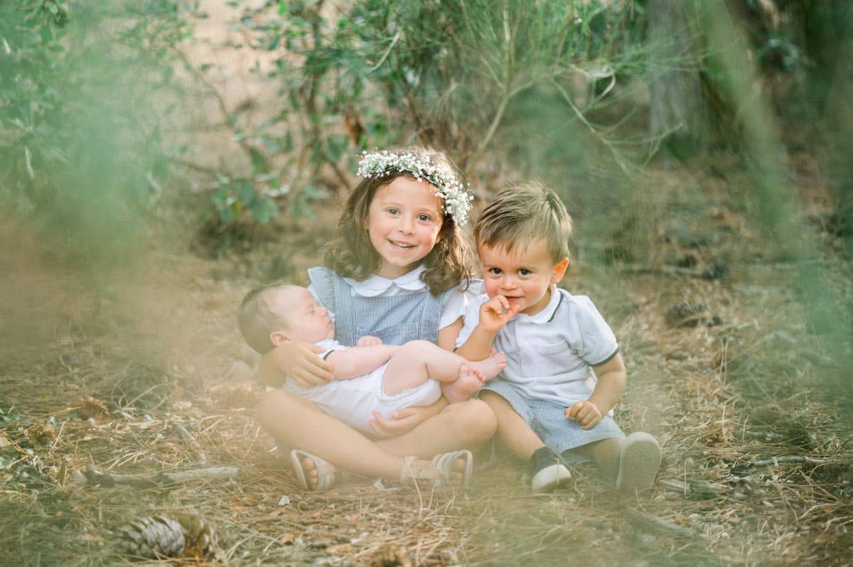 Children sitting in the grass during a family photo session at Piraillan reservoir