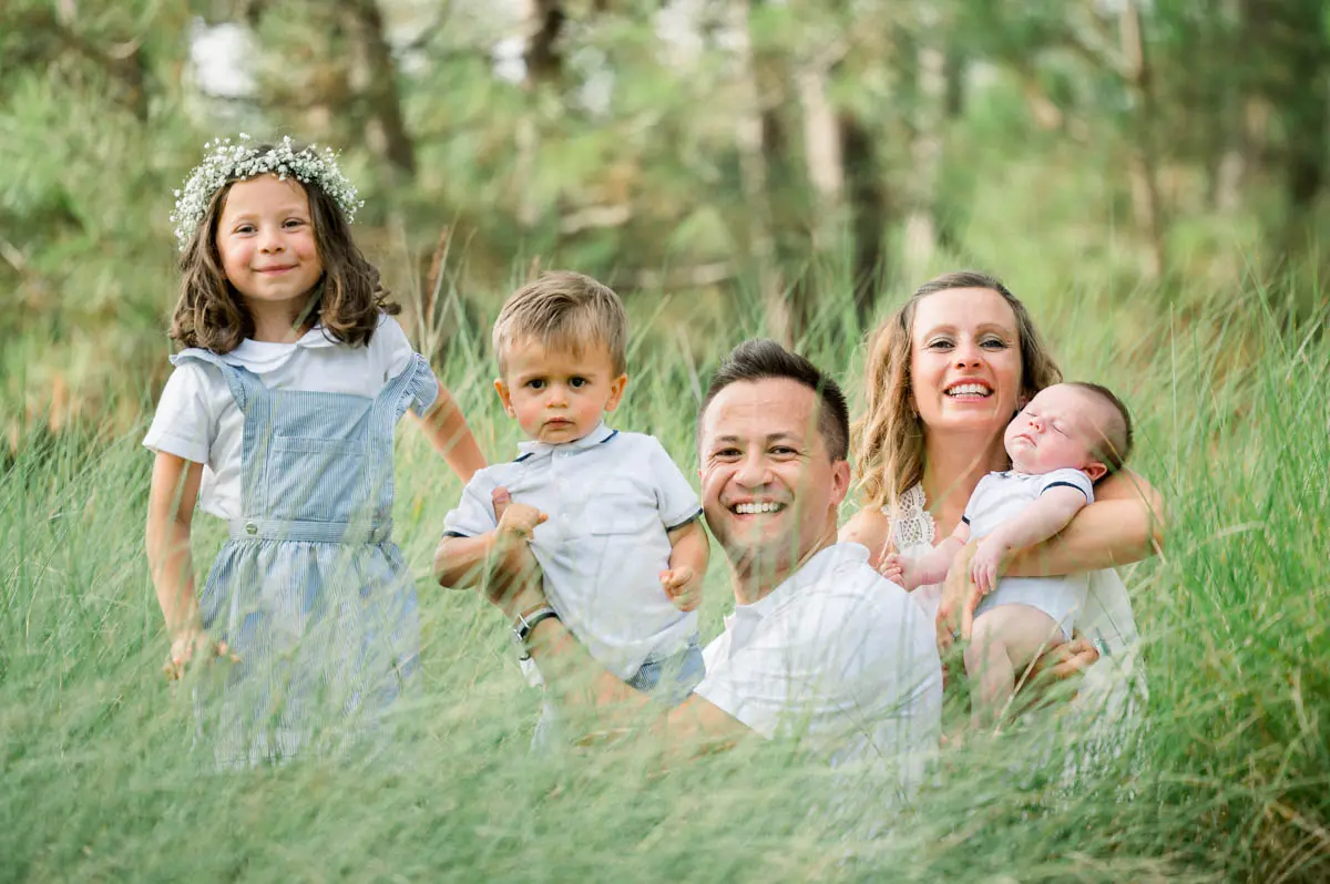 Family photo with three children sitting in the grass at the Piraillan reservoirs