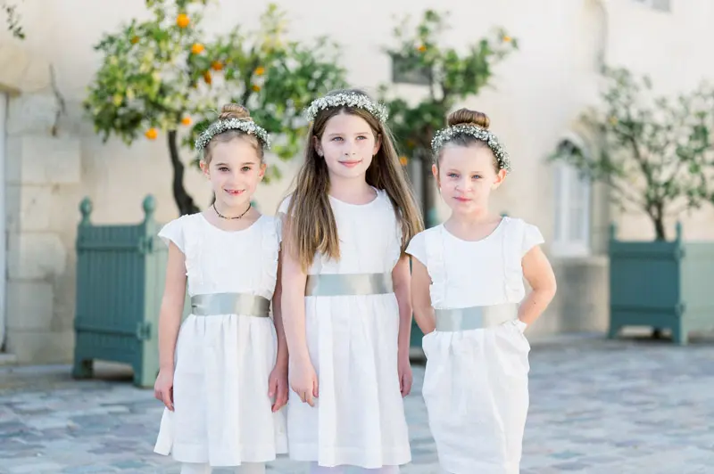 Trois petites filles d'honneur en robe blanche et couronne de fleurs