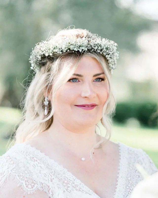 Portrait of the smiling blonde bride with a gypsophila crown
