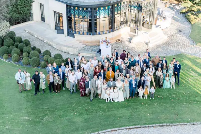 Aerial group photo of all the guests in front of the château orangery