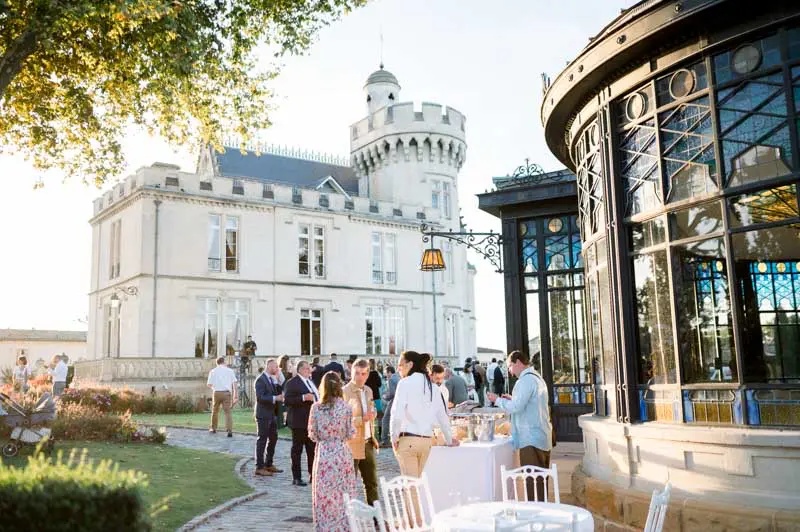 Wedding drinks on the terrace between the château and the glass orangery
