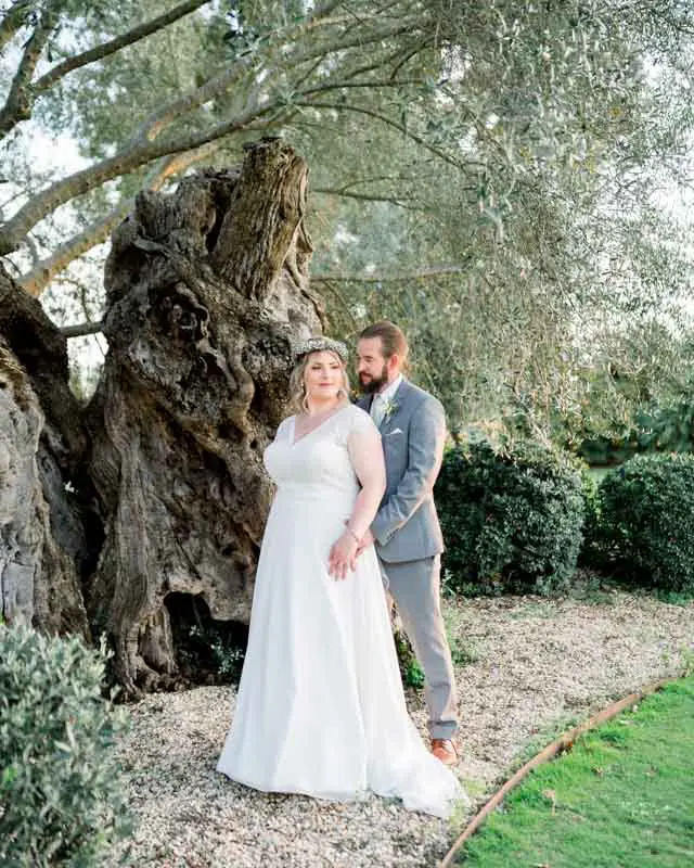 Julie and Derek embracing at the foot of the old olive tree at Château Pape Clément