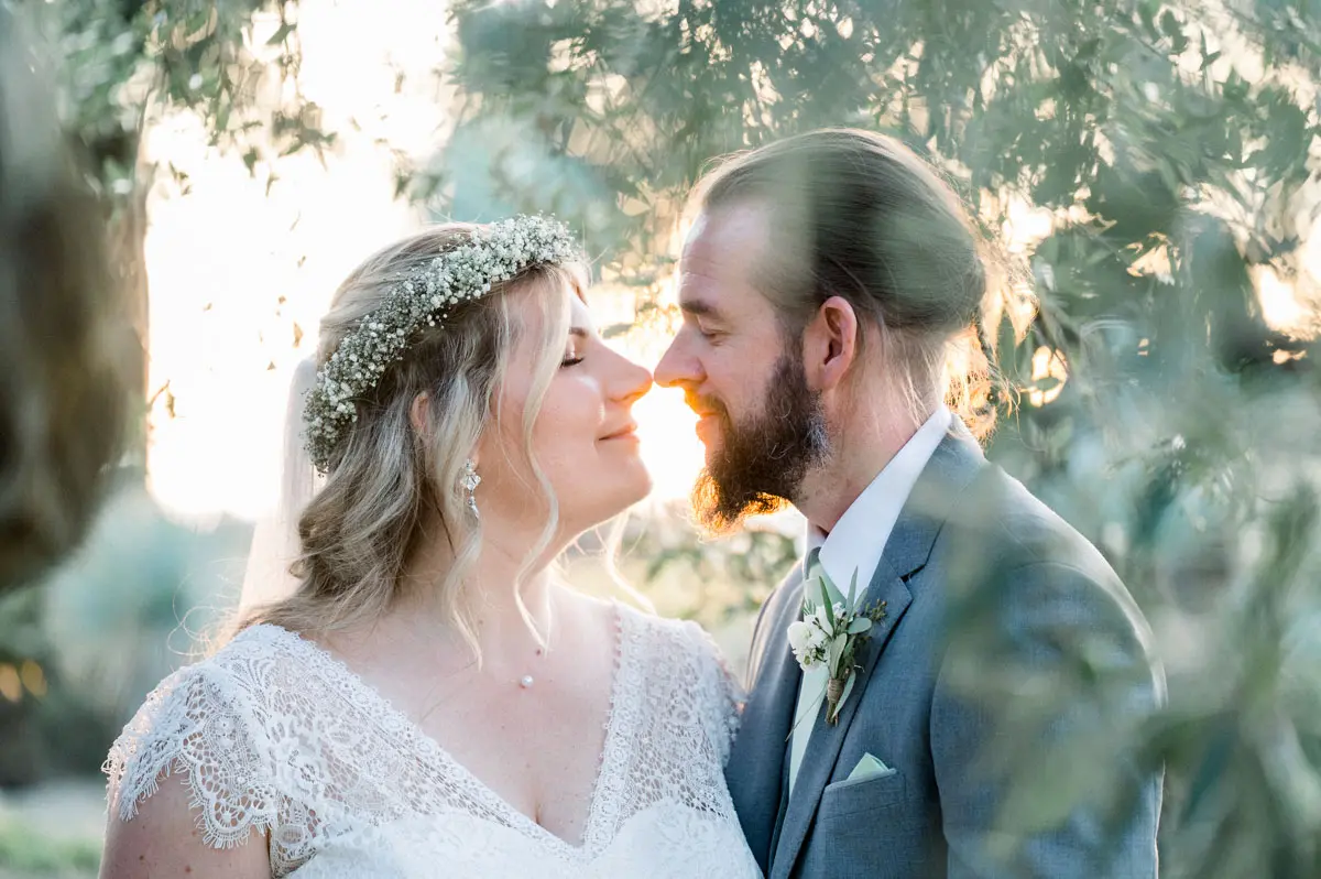 Bride in a flower crown nose to nose with the groom at Château Pape Clément