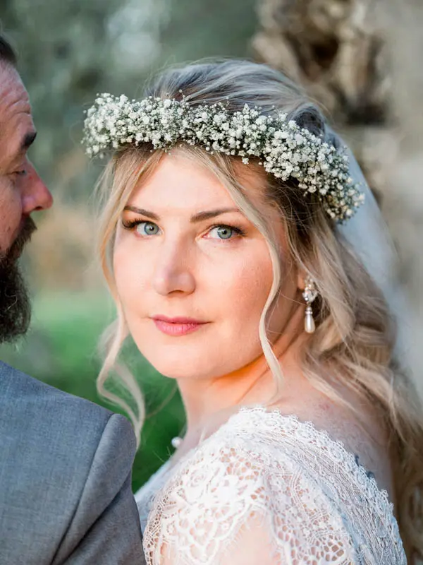 The flower-crowned bride gazing over the groom's shoulder