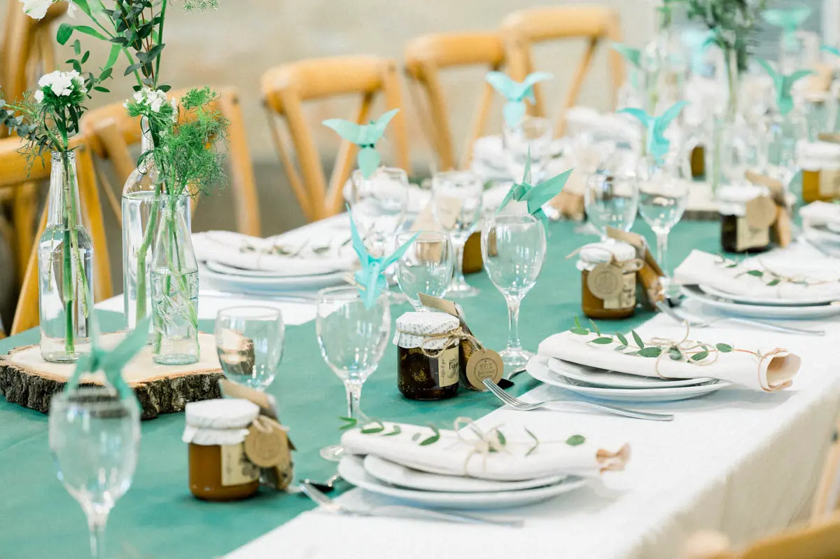 Table detail with a sea-green runner, small jars and wooden slices