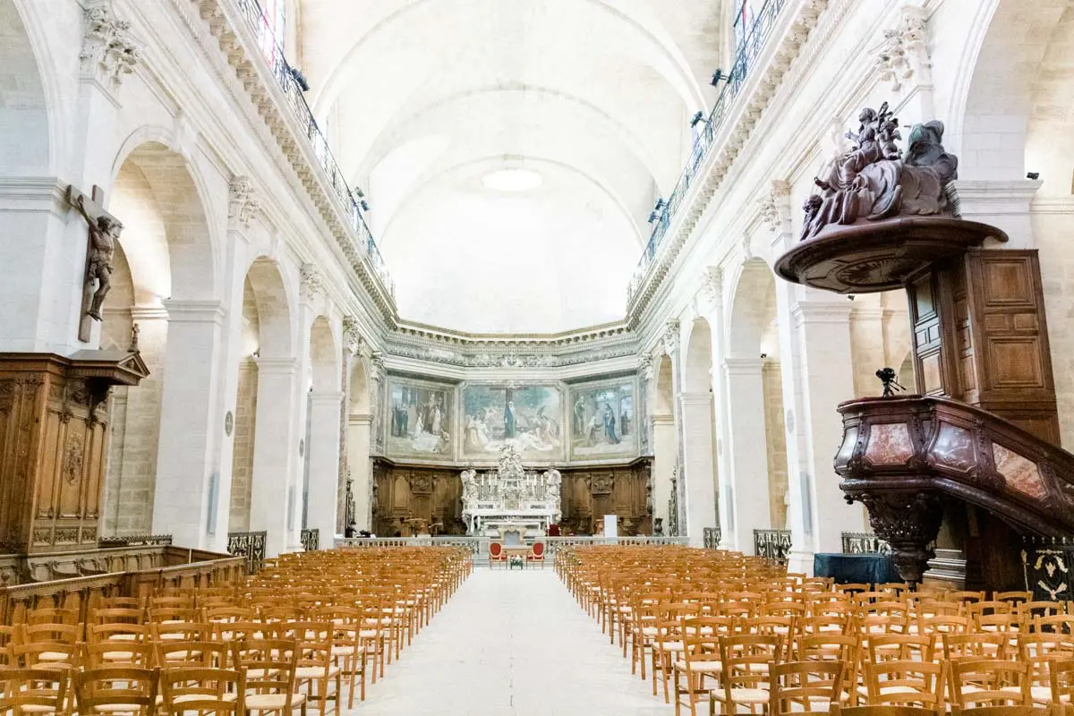 Bright nave and straw chairs of Notre-Dame church in Bordeaux