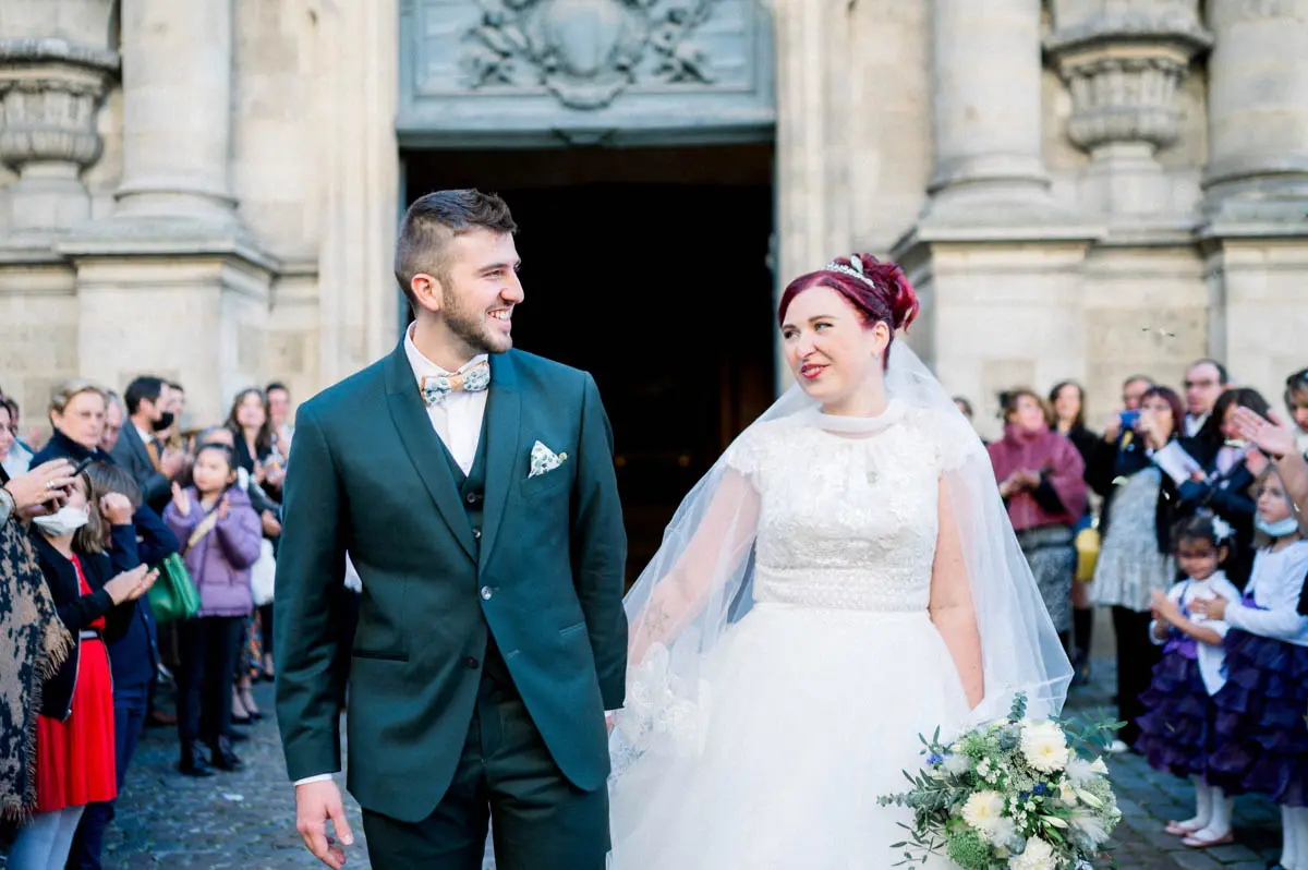 The couple stepping out onto the church square surrounded by guests