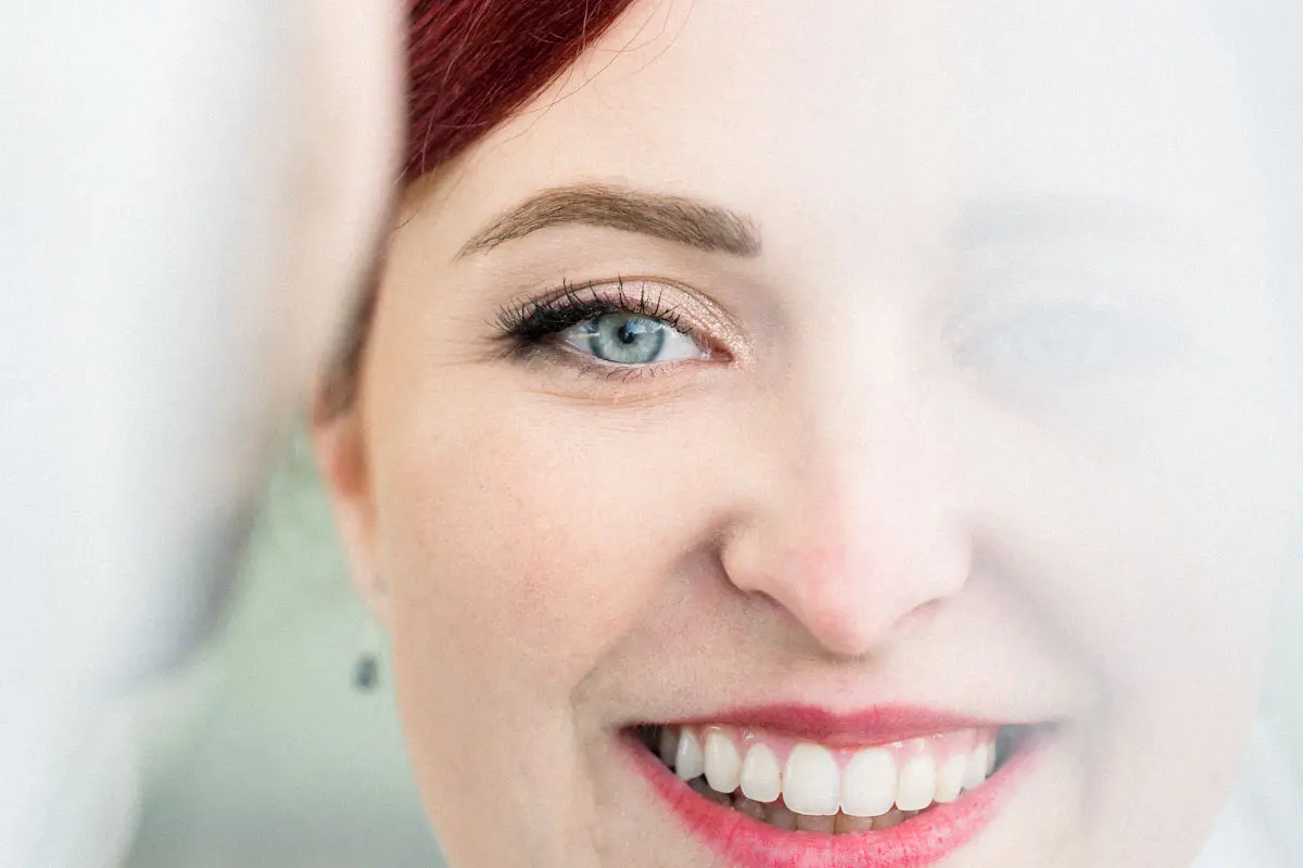 Close-up of the red-haired bride's smile and blue eyes