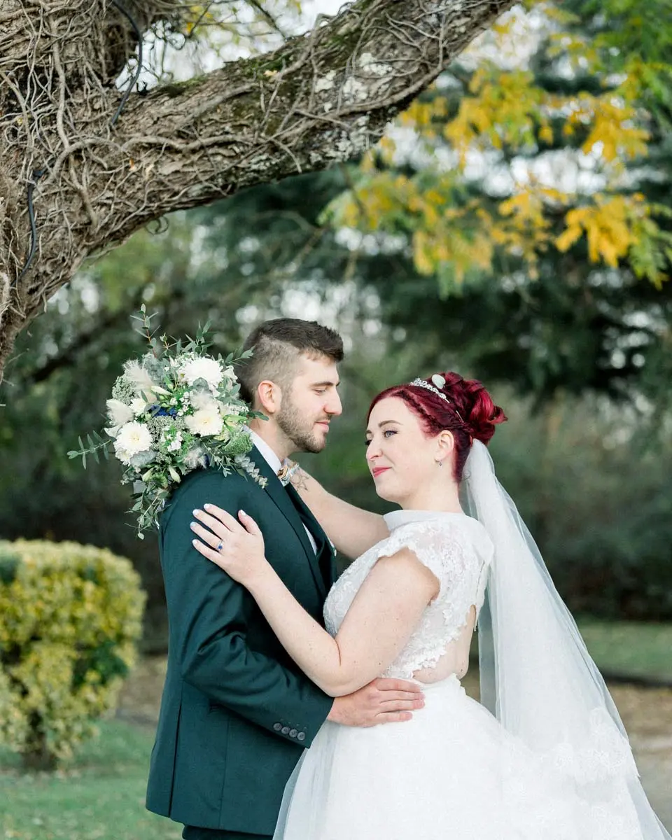 Tiffa and Geo embracing beneath the branches in the estate grounds