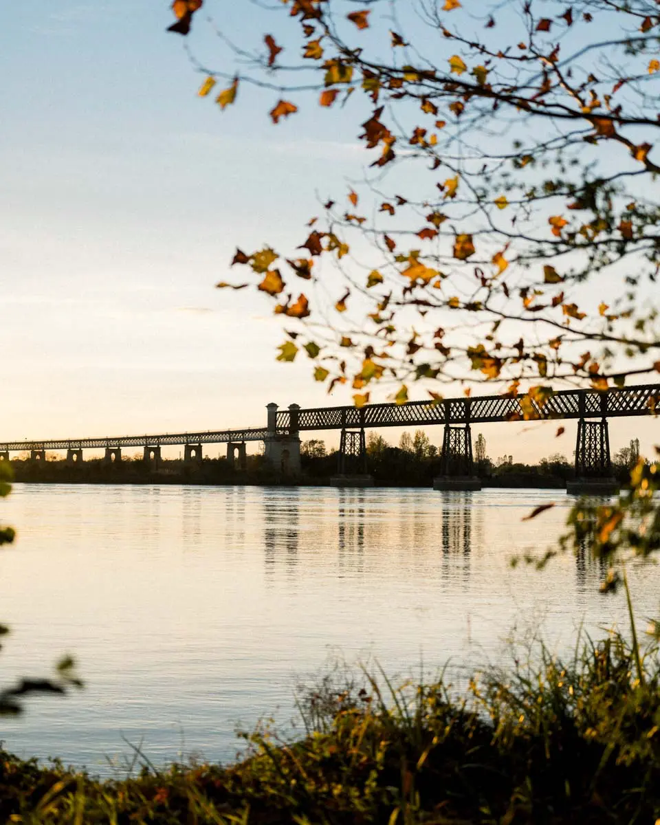 Sunset over the water and a metal bridge at Cubzac-les-Ponts