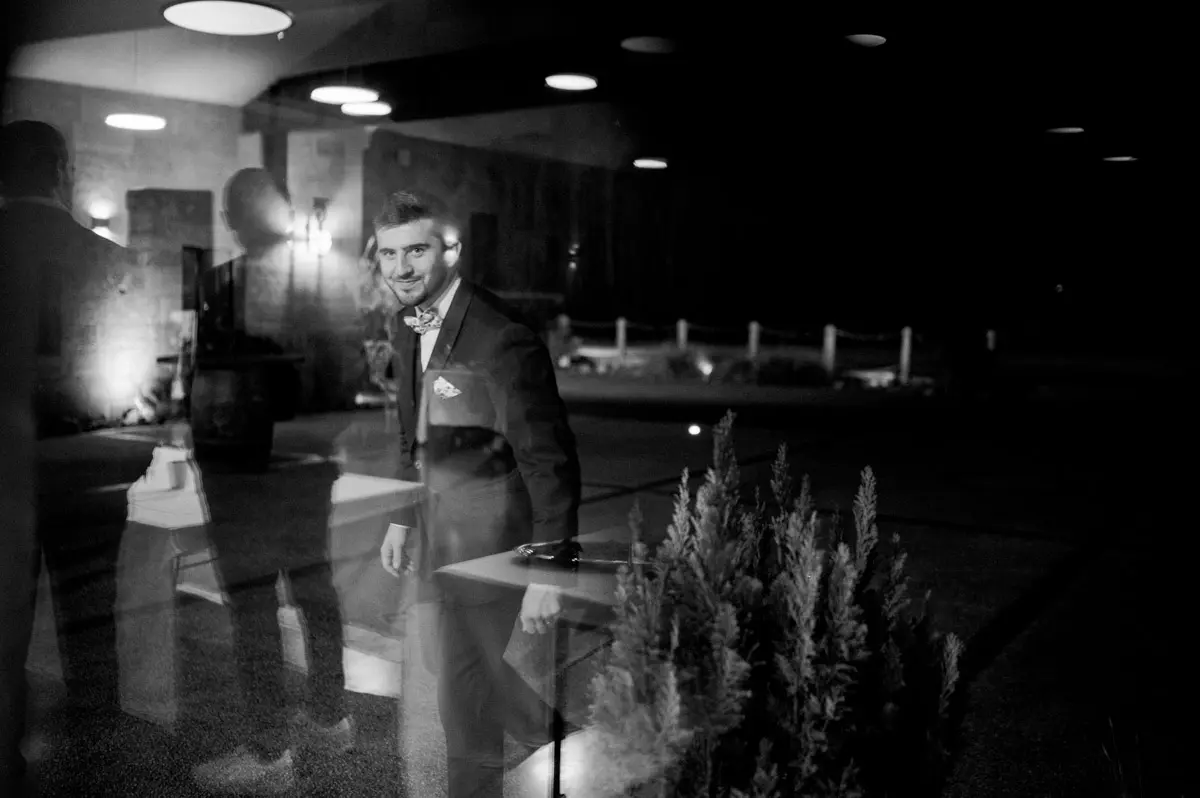 The groom in the dim hall before the evening entrance, in black and white