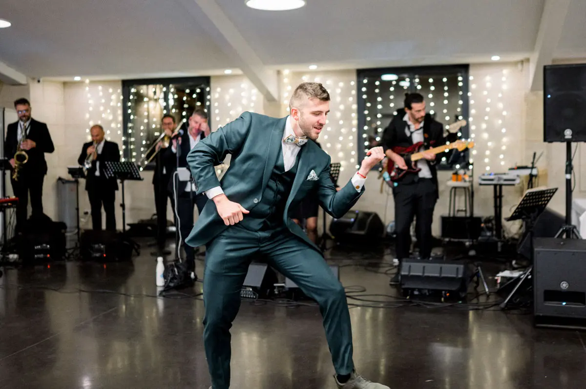 The groom dancing in front of the band at Domaine de Conseillant
