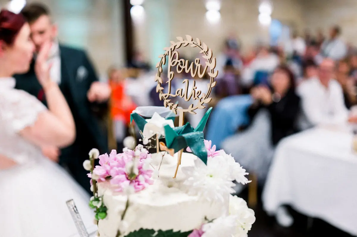 Flower-decorated wedding cake topped with a wooden cake topper