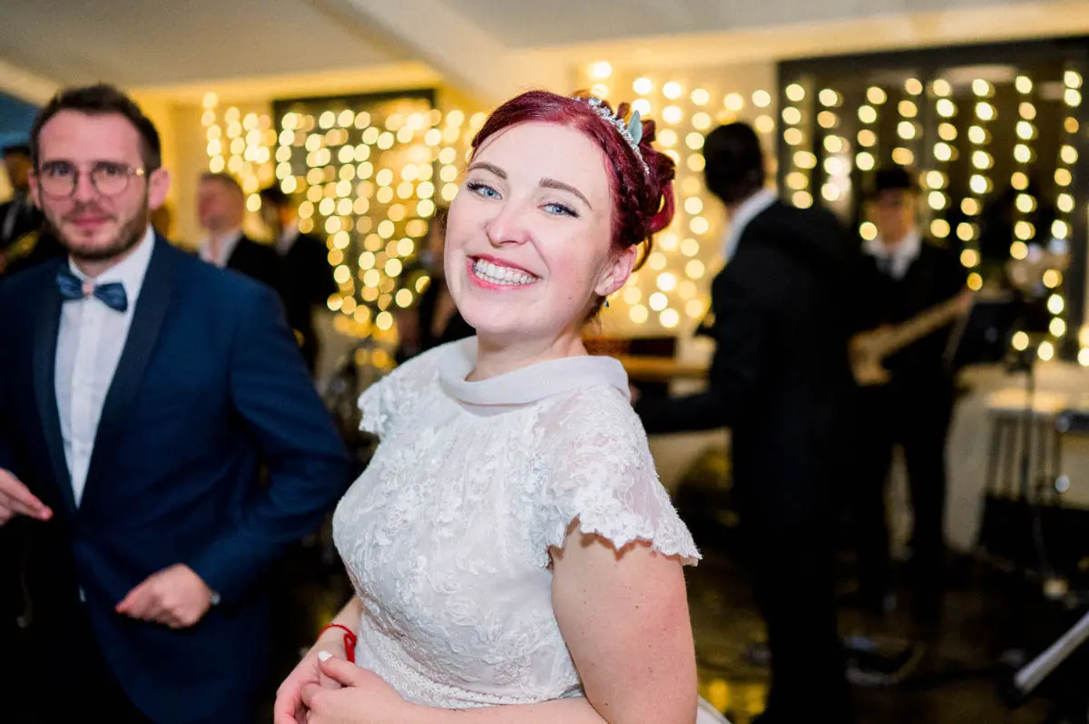 The radiant bride on the dance floor before the string lights