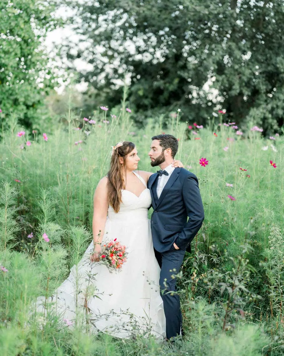 Bride and groom embracing in the middle of a wildflower meadow