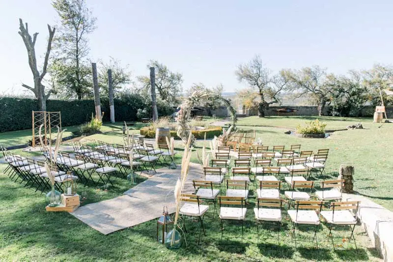 Ceremony chairs lined up on the lawn facing the floral arch