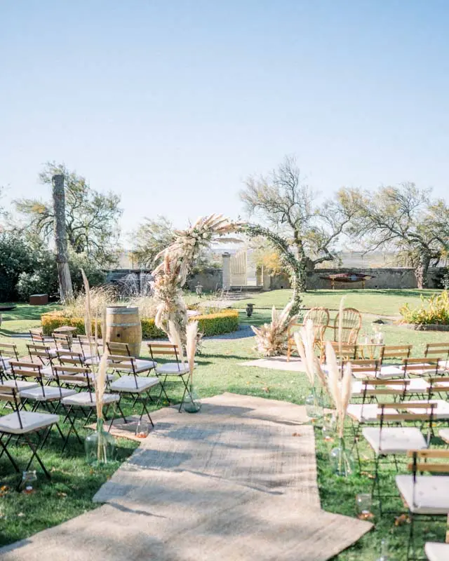 Jute aisle leading to a pampas grass ceremony arch in the garden