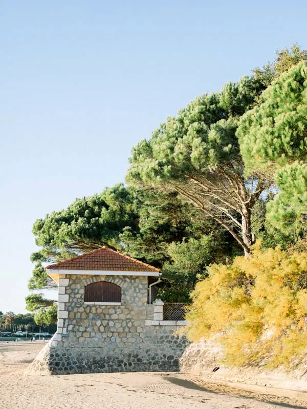 Small stone hut on the beach surrounded by pines on Arcachon Bay