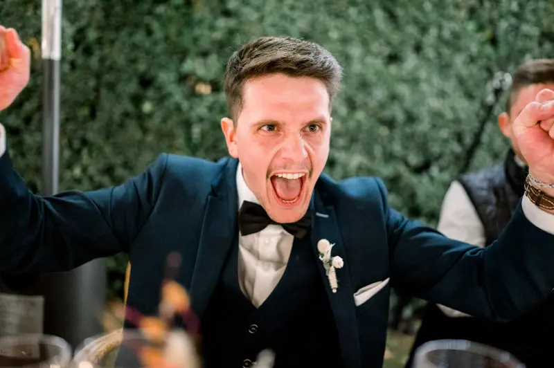 Groom cheering as the couple make their entrance into the reception tent
