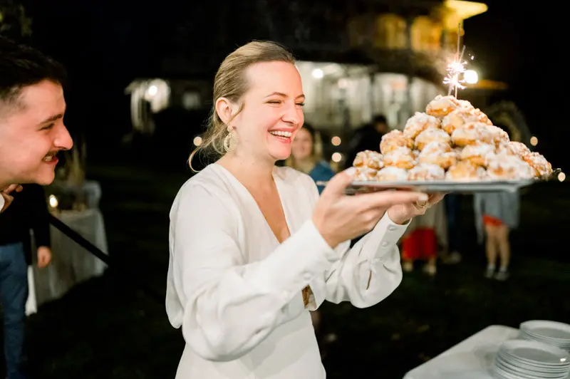 Bride carrying a platter of cream puffs for dessert in the evening