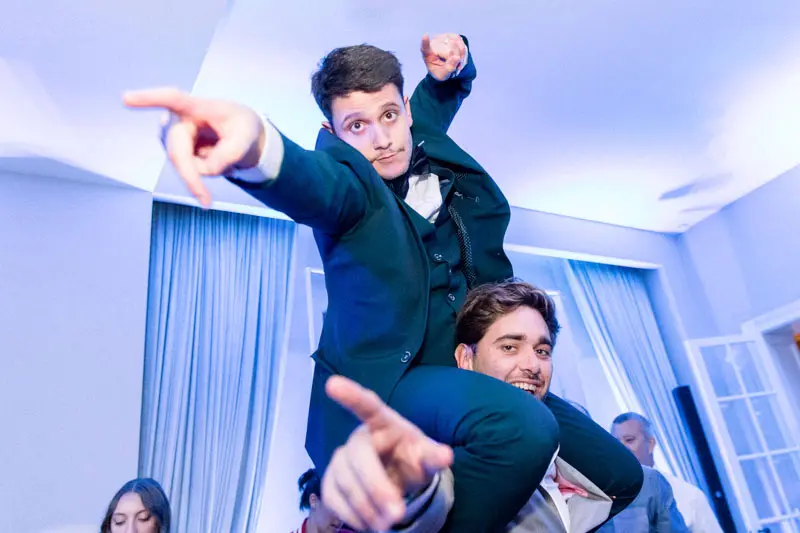 Groom carried on a friend's shoulders on the dance floor