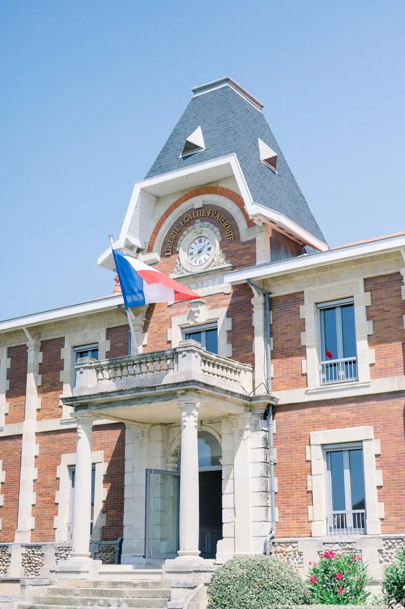 Brick façade and French flag of Soulac-sur-Mer town hall on the wedding day
