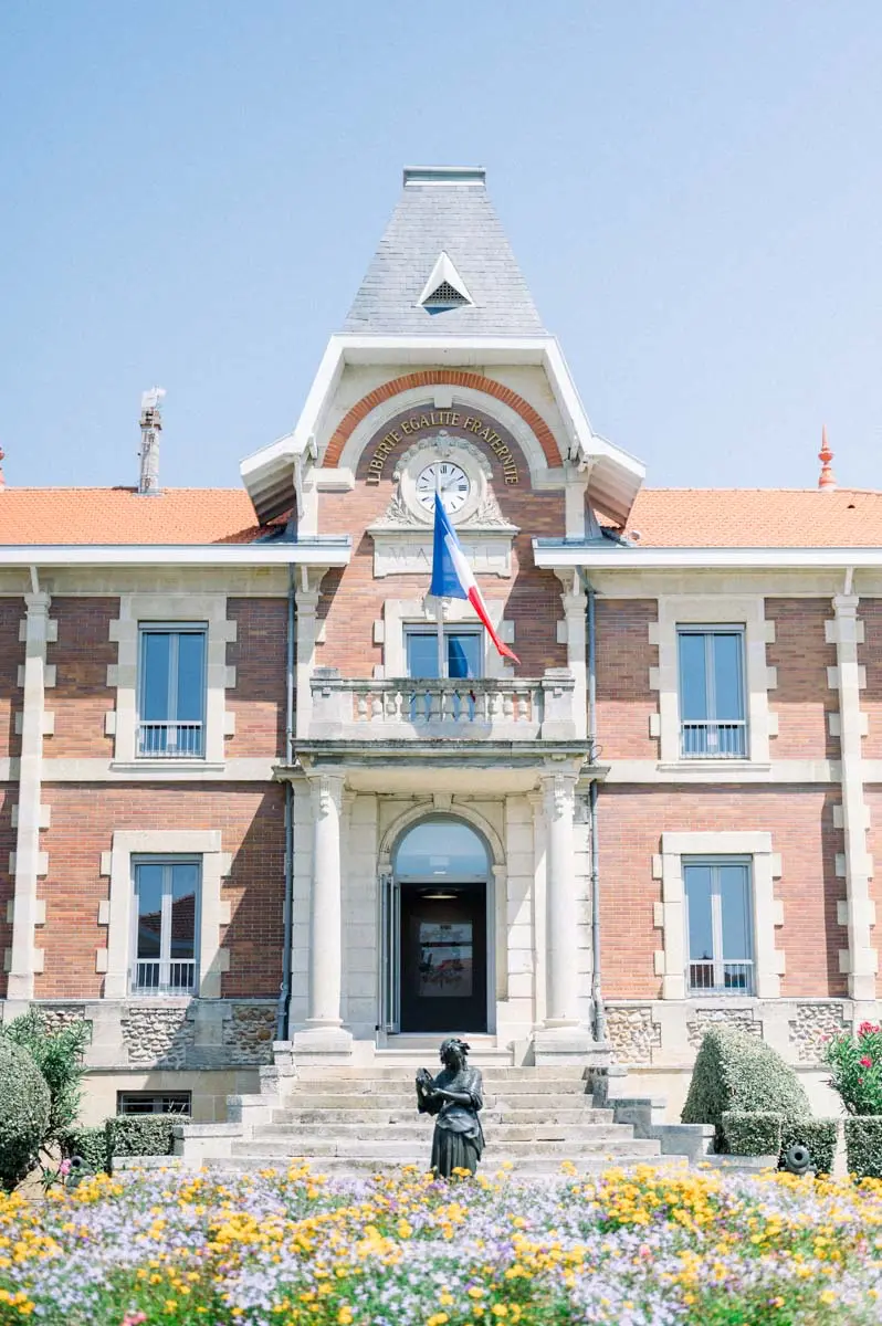 Soulac-sur-Mer town hall and its flower beds under a blue sky