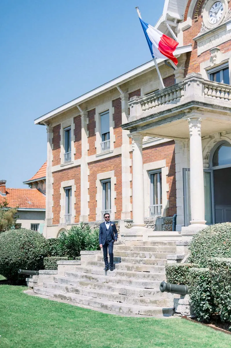 The groom waiting on the steps of Soulac-sur-Mer town hall