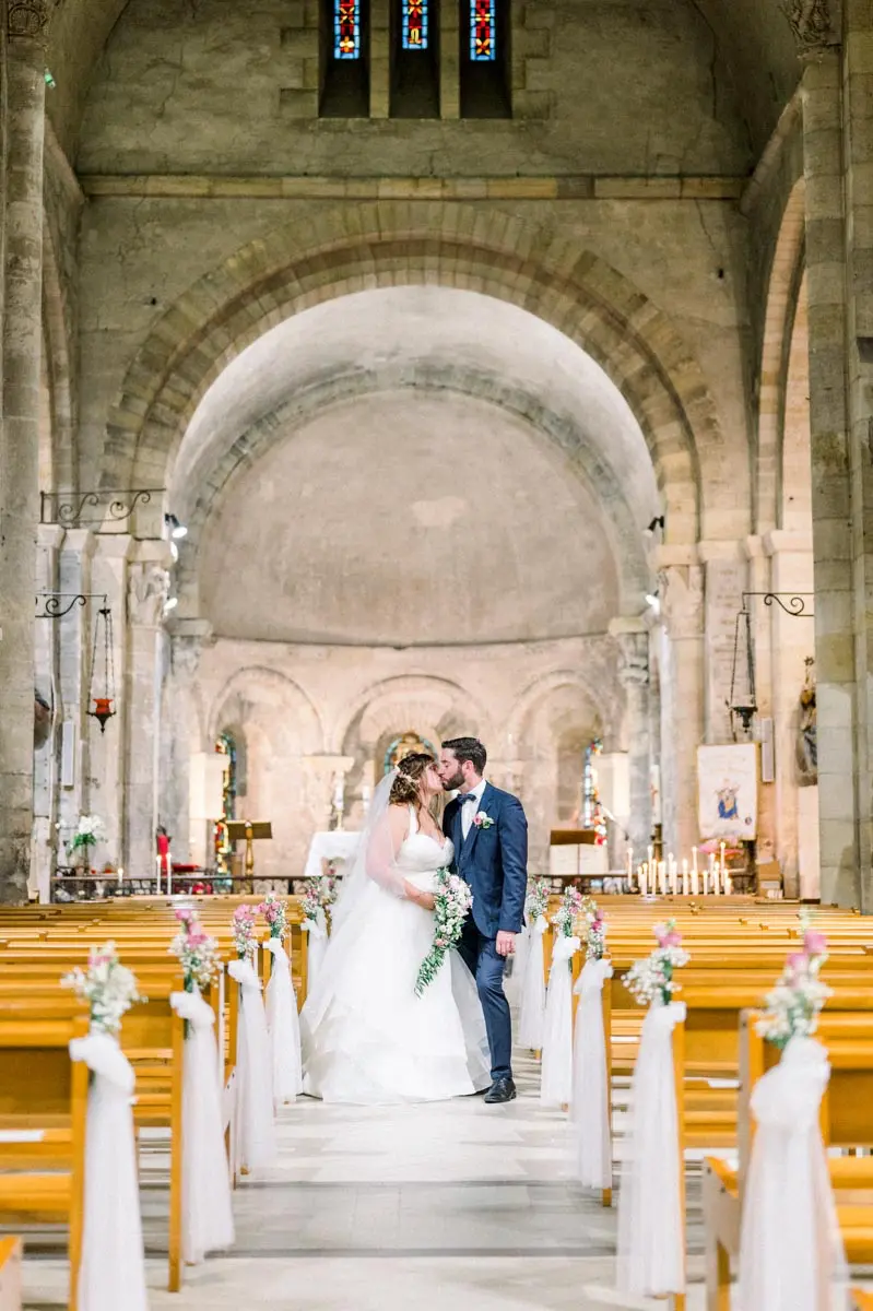 Bride and groom kissing in the aisle of Notre-Dame-de-la-fin-des-Terres basilica