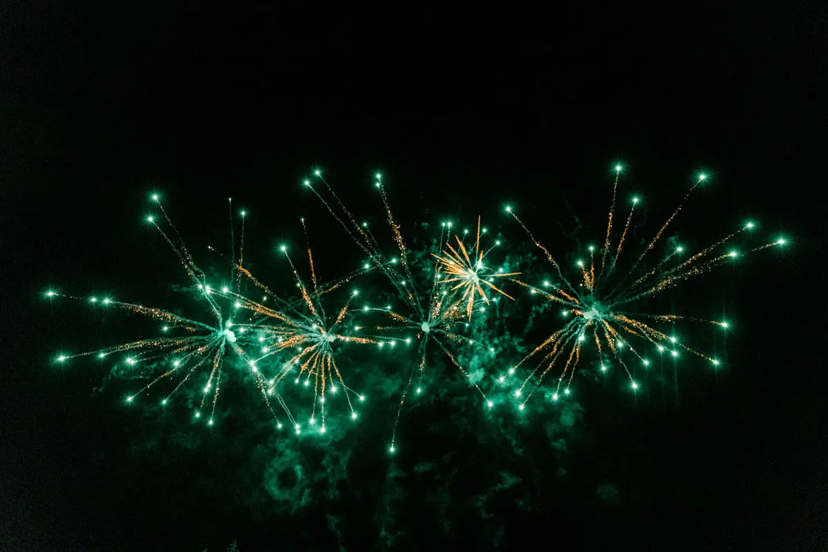 Green fireworks lighting up the night sky during the wedding reception