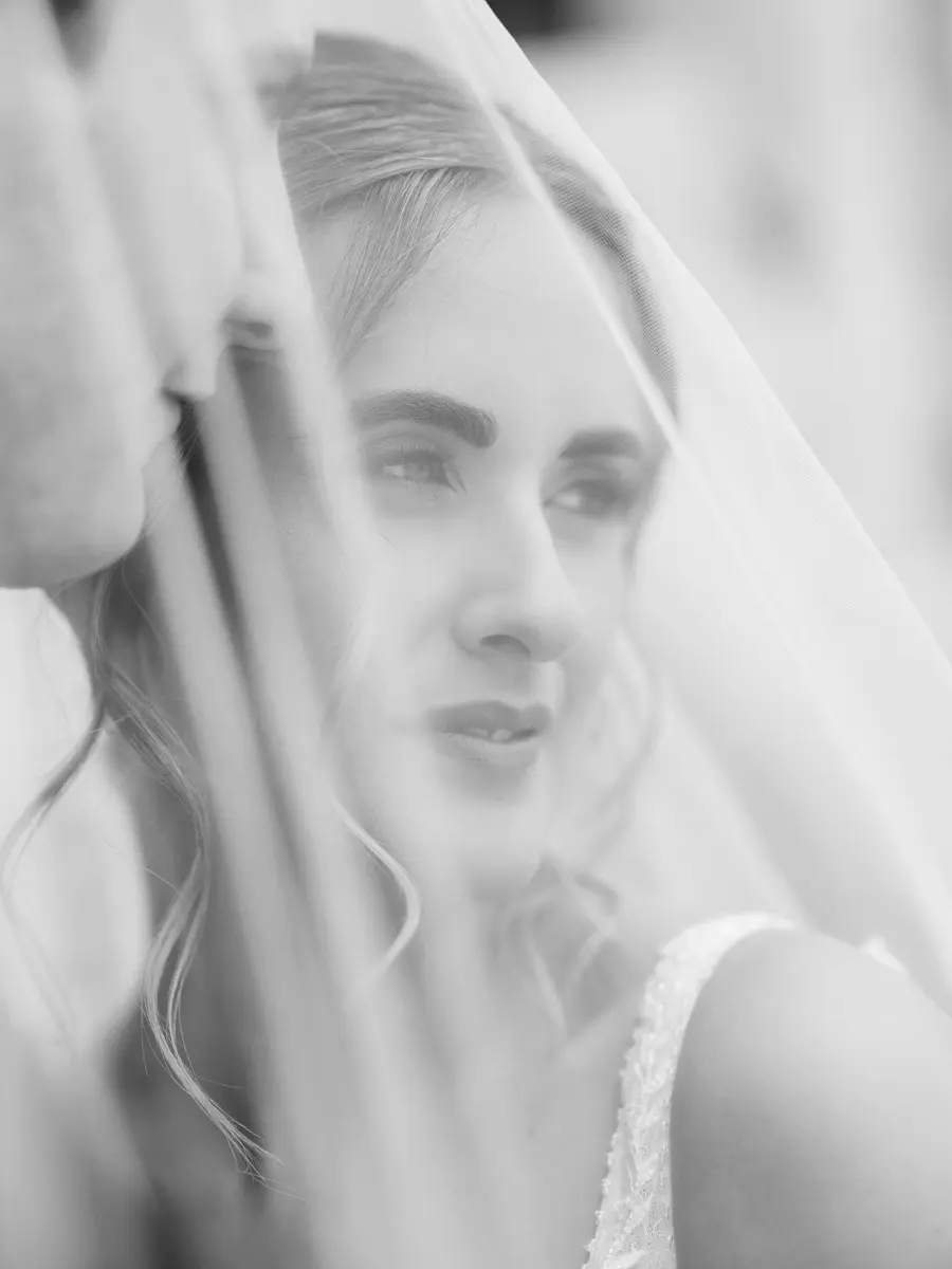 Black and white portrait of a bride under her veil, editorial wedding photography