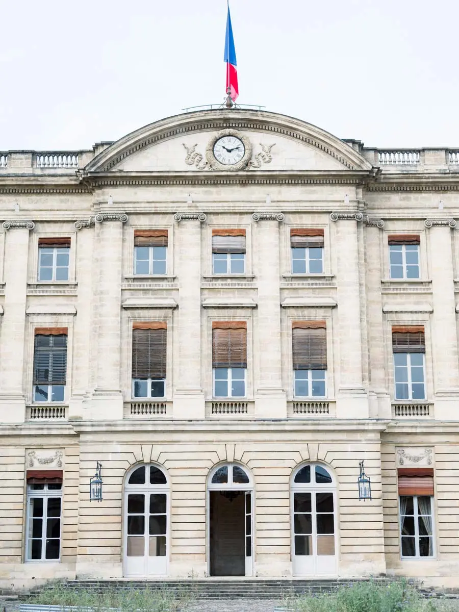 Bordeaux town hall façade with its clock and the French flag
