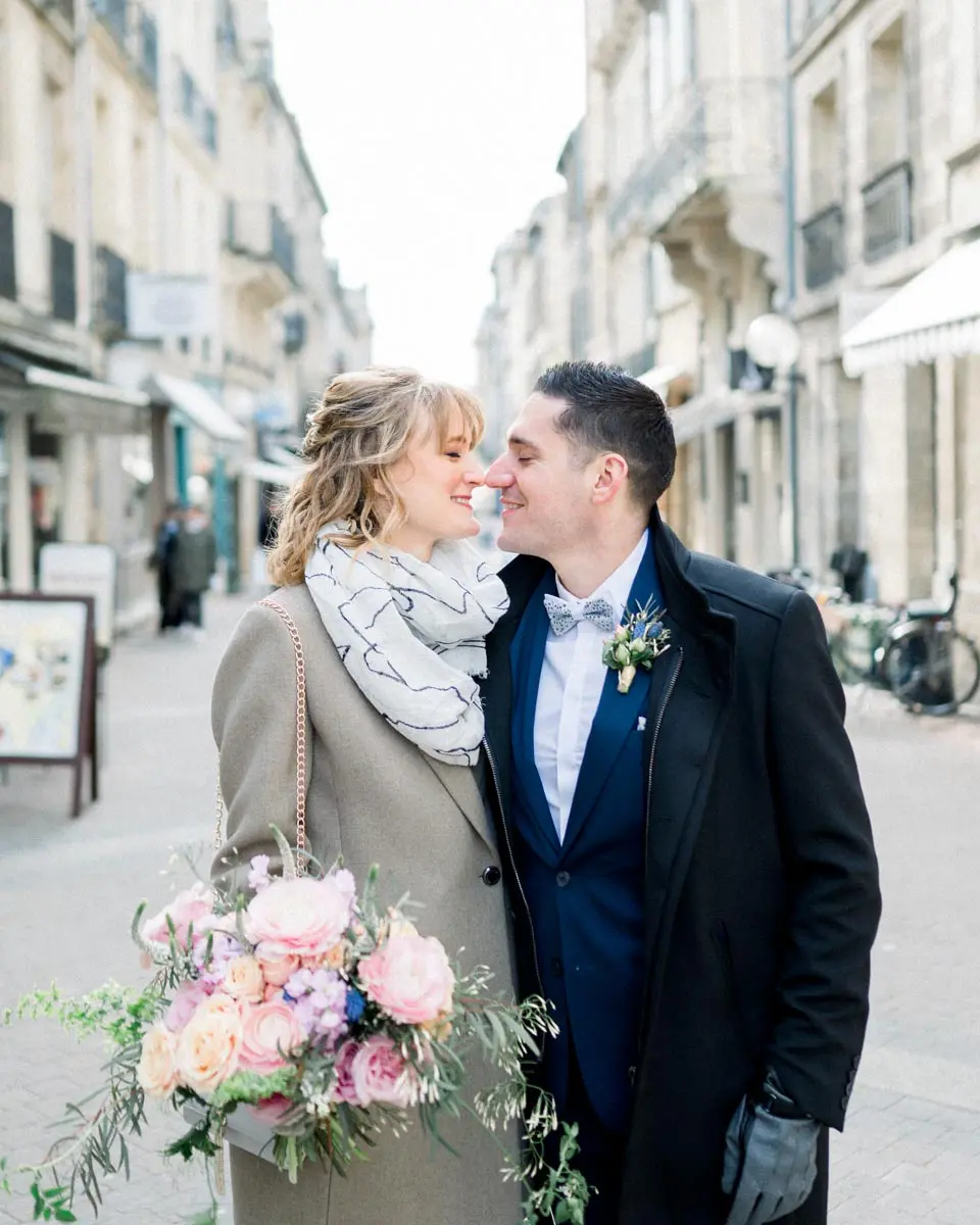 The couple in winter coats nose to nose on a Bordeaux street