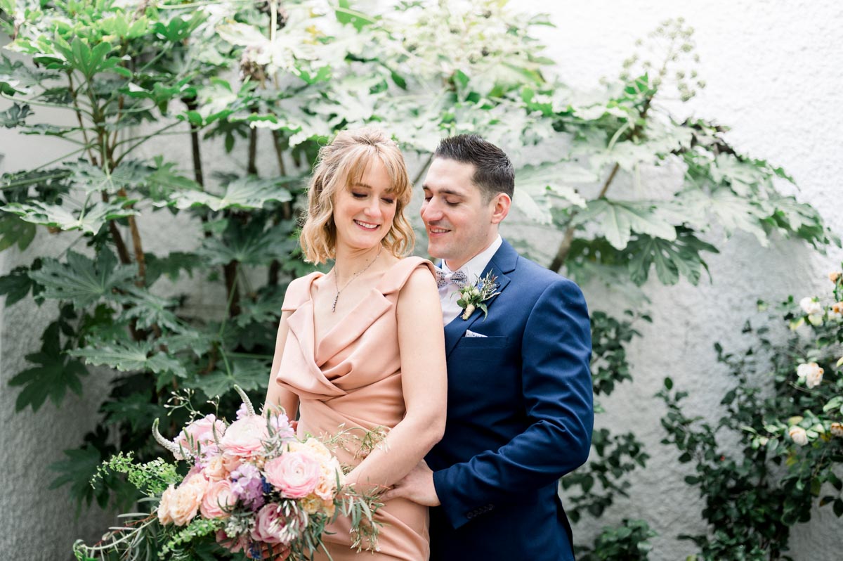 Couple by an ivy-covered wall after their civil wedding in Bordeaux