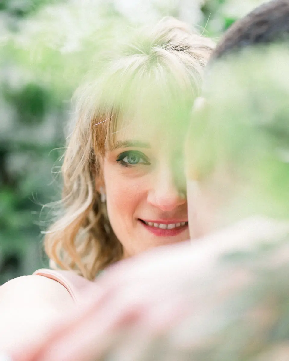 The bride's smiling gaze through the foliage